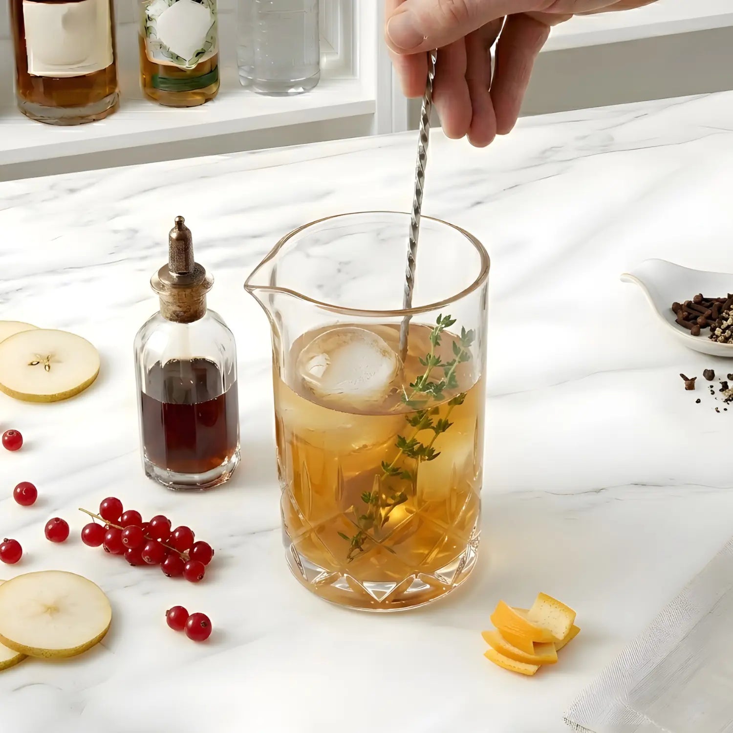 A mixing glass being used to stir a cocktail