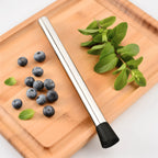10 inch muddler next to berries and herbs