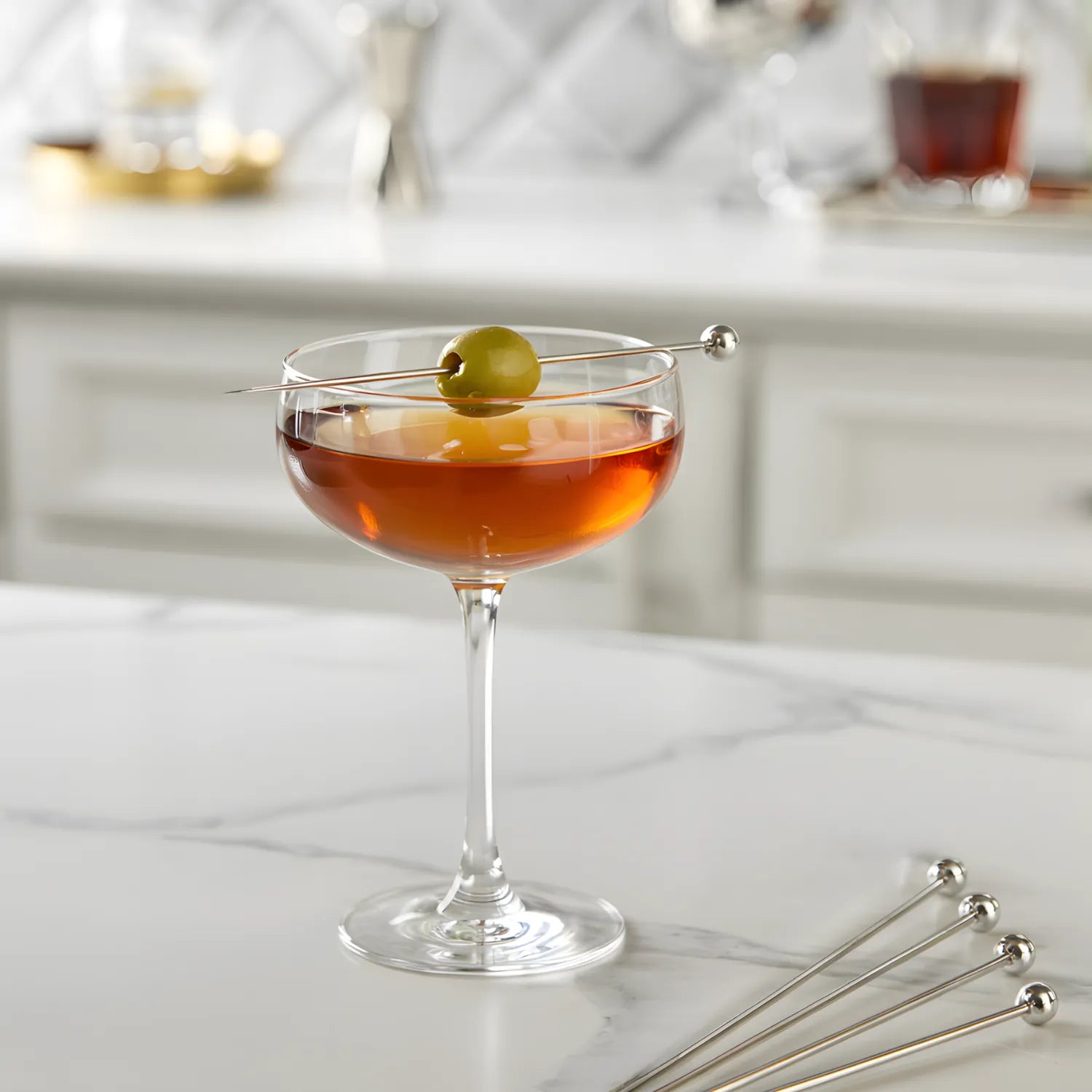 ball cocktail pick speared through a olive