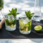 two cocktails placed on a small bar mat