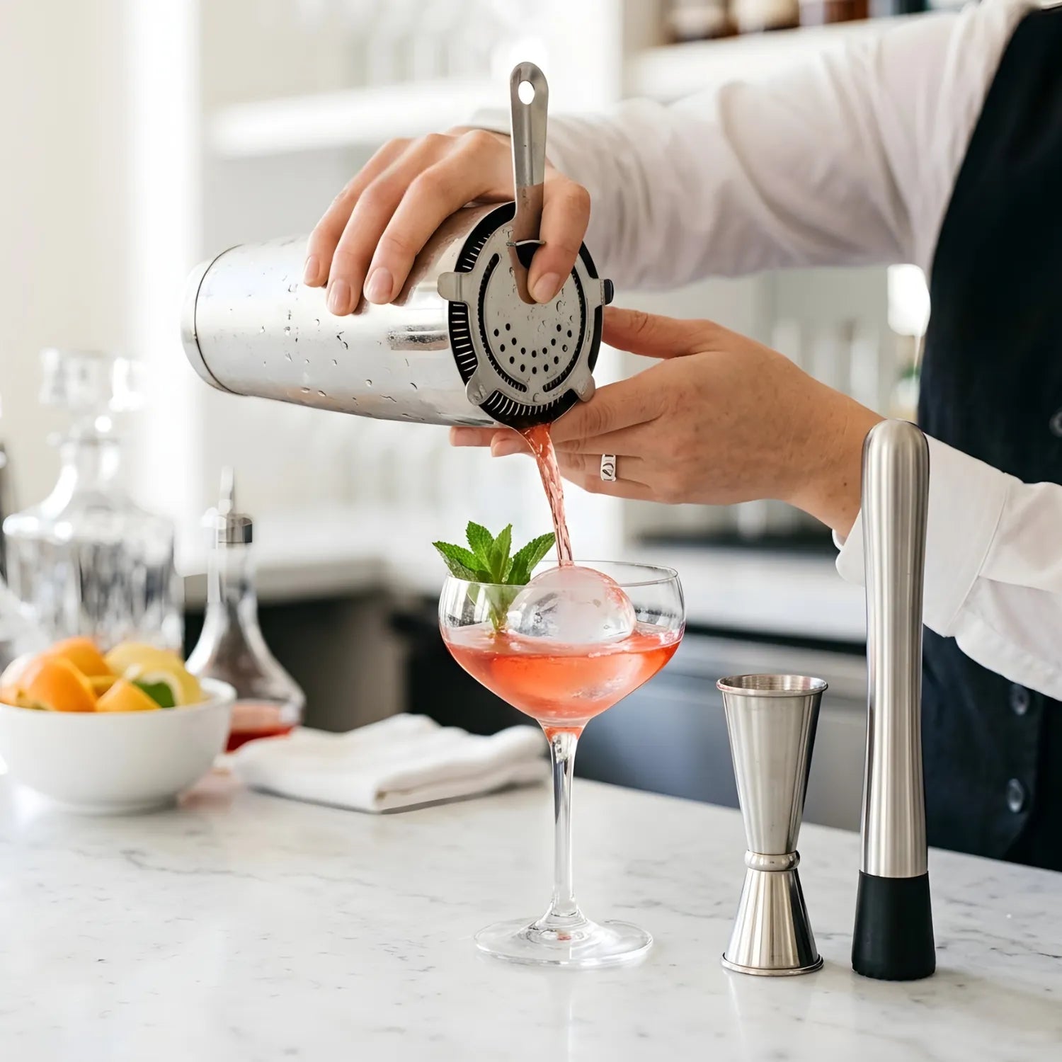 Bartender using bar tools to strain a cocktail