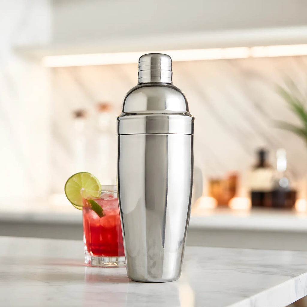 cobbler shaker placed next to a finished cocktail