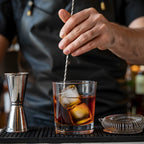 flat end bar spoon is stirring in a glass