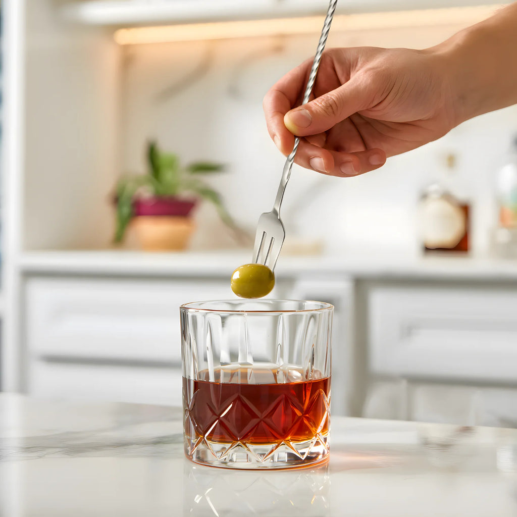 fork end bar spoon picking up an olive