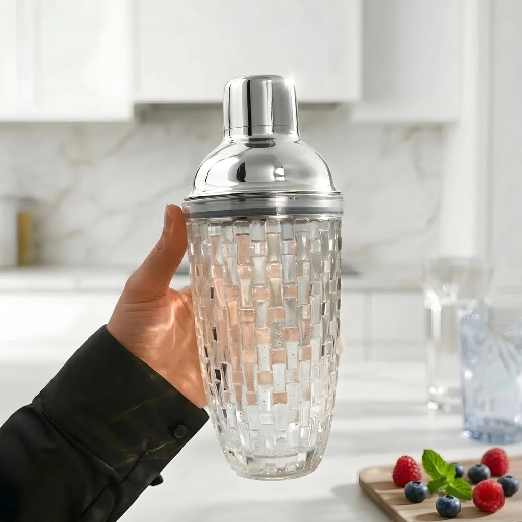 bartender holding a glass cocktail shaker