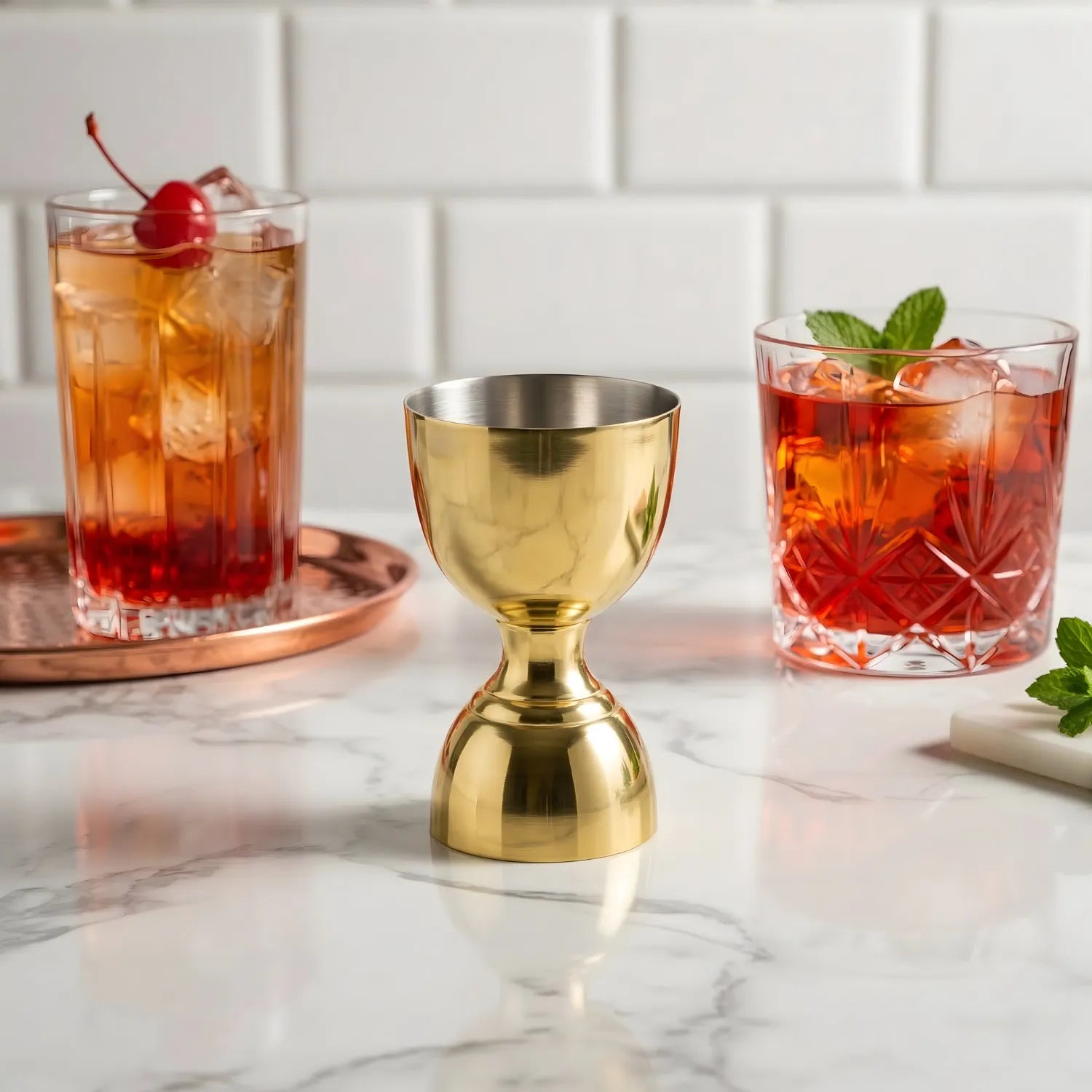 gold bell jigger next to cocktails