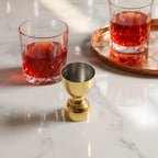 gold bell jigger on a home bar counter