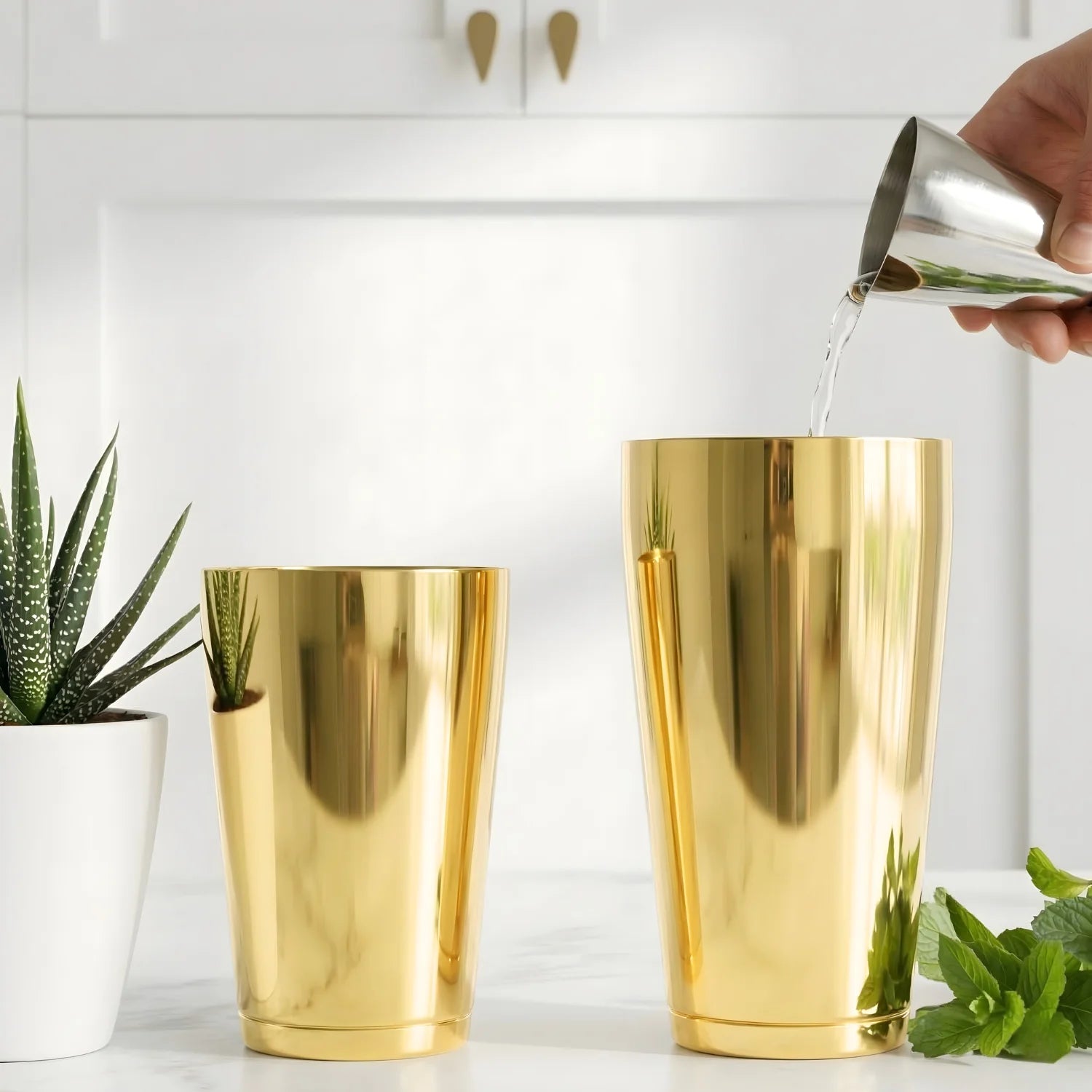 bartender pouring liquor with a jigger into a large gold Boston tin