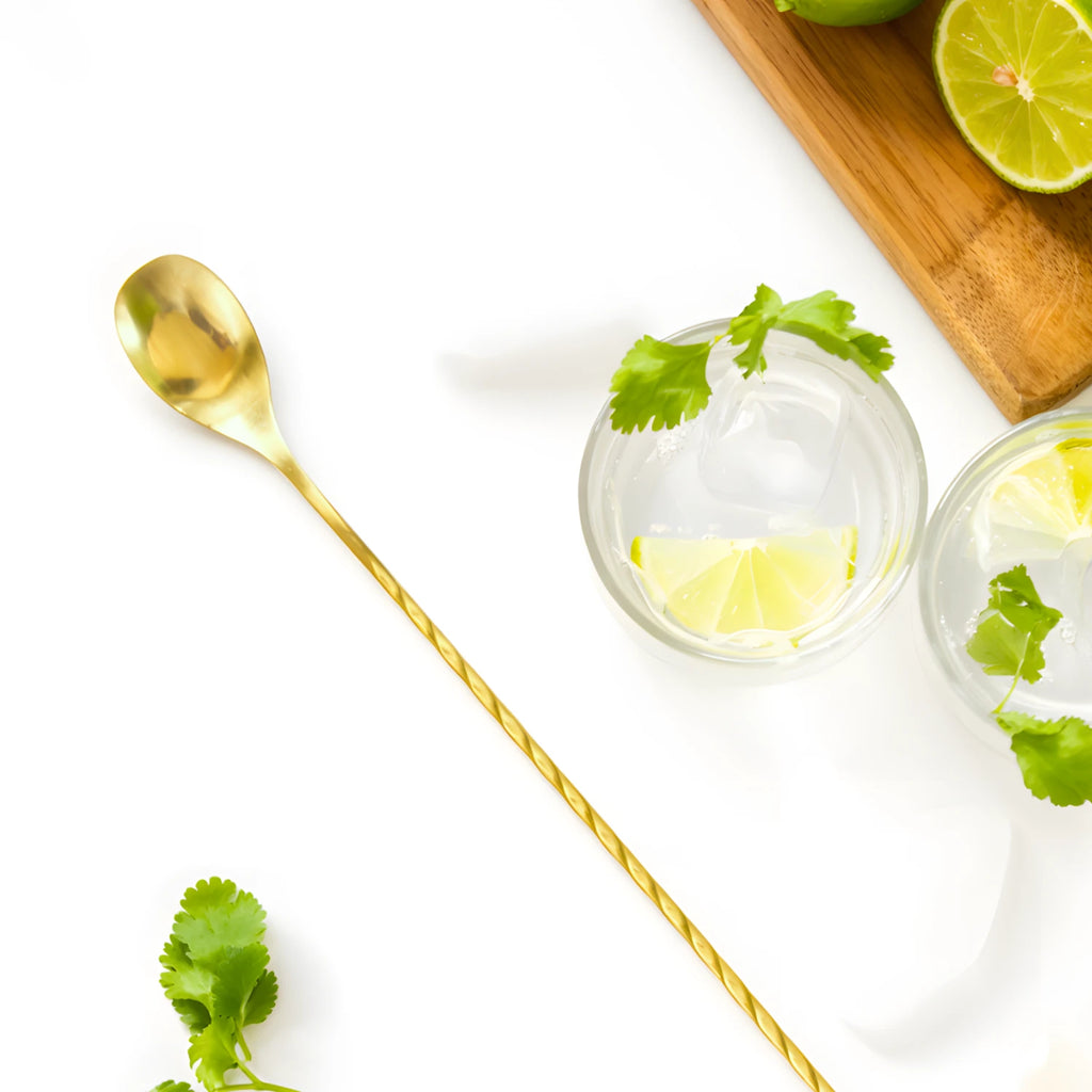 gold teardrop bar spoon on a home bar counter