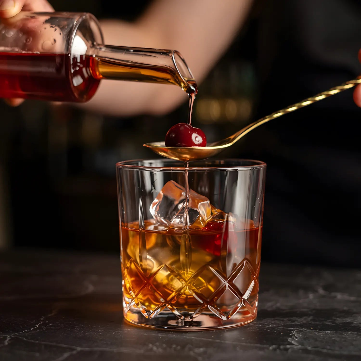 bartender using a gold teardrop bar spoon