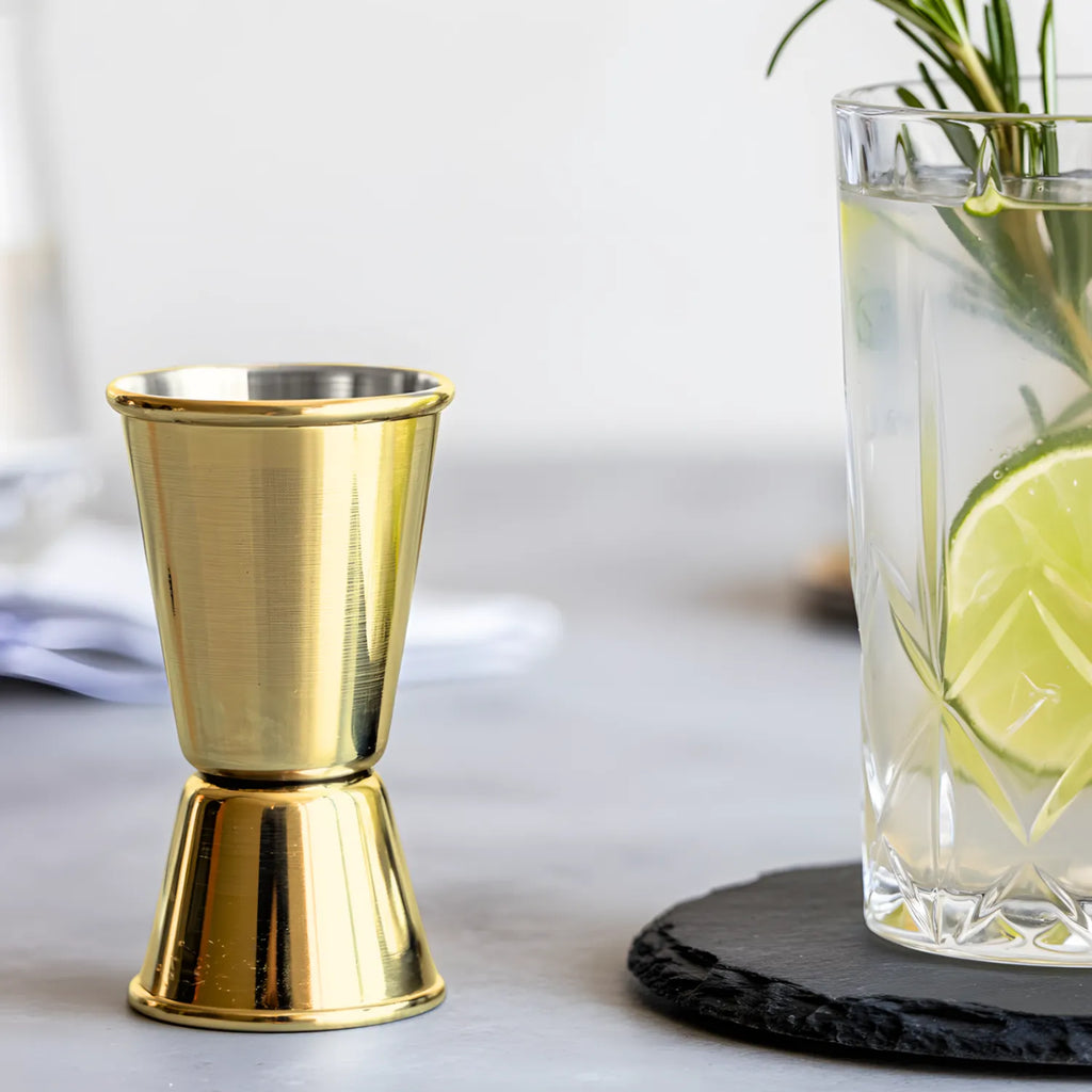 gold classic jigger next to a cocktail