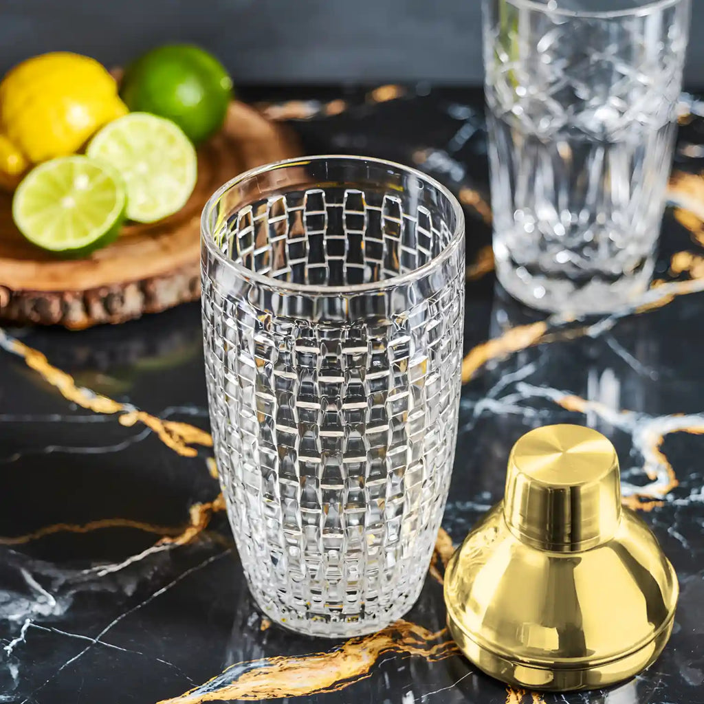 gold glass cocktail shaker taken apart and laid out on a table