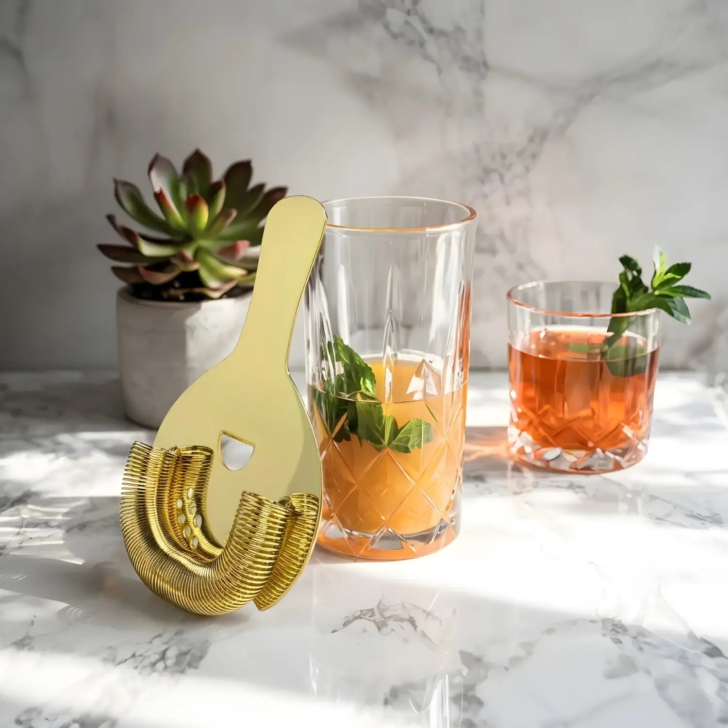 gold Hawthorne strainer next to a cocktail