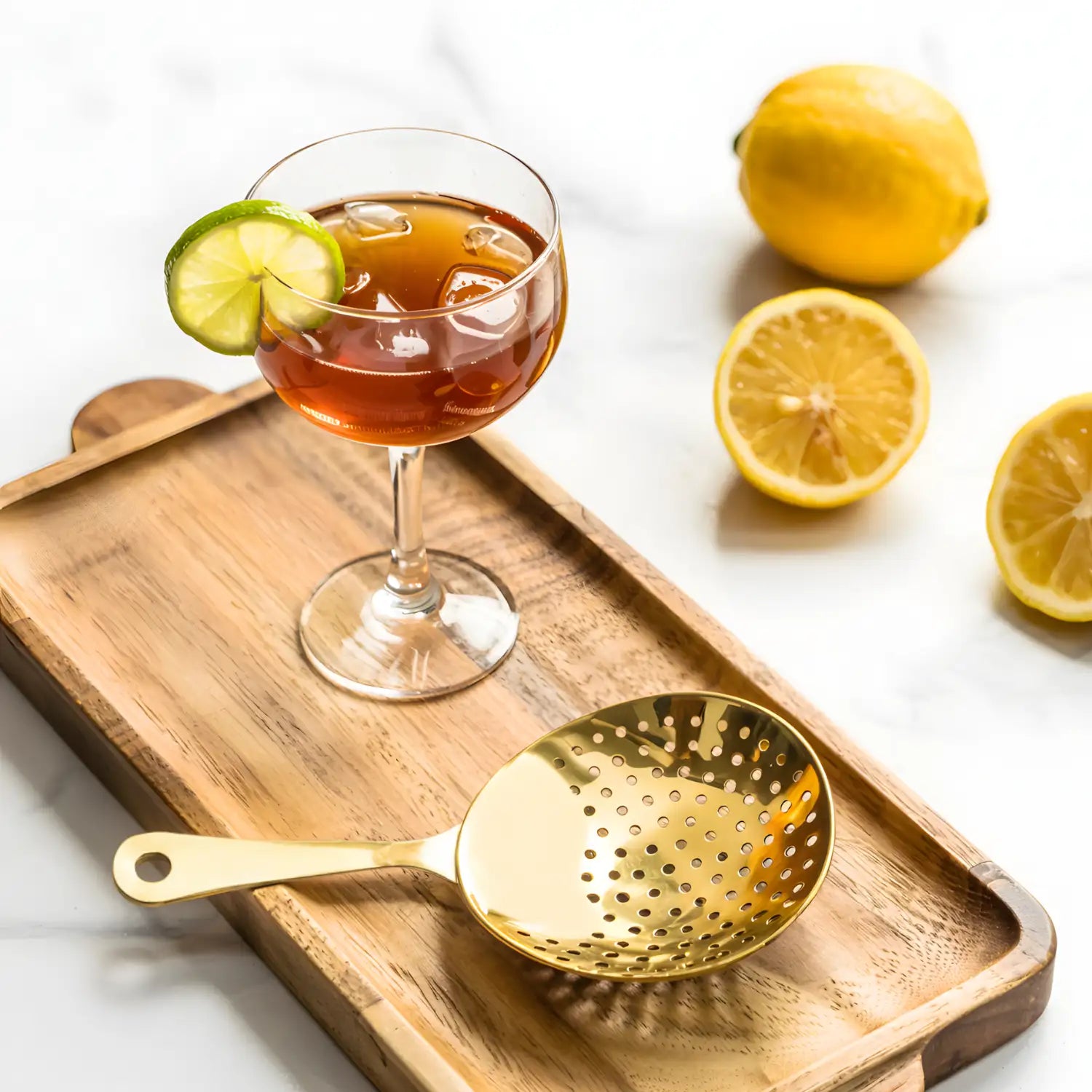 gold Julep strainer on a home bar counter