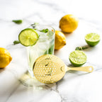 gold Julep strainer next to a cocktail
