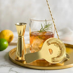 gold mixing glass cocktail set on a home bar counter