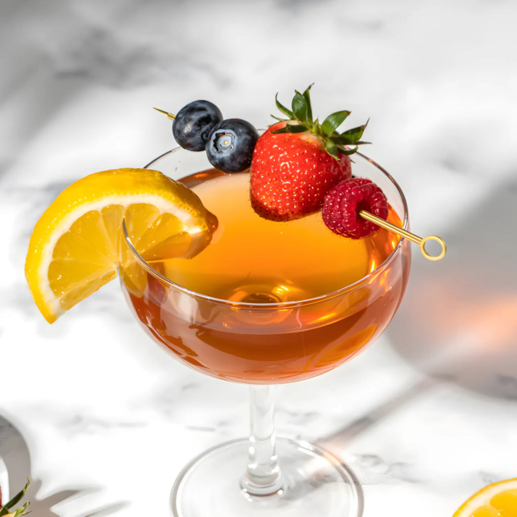 gold ring cocktail pick speared through berries