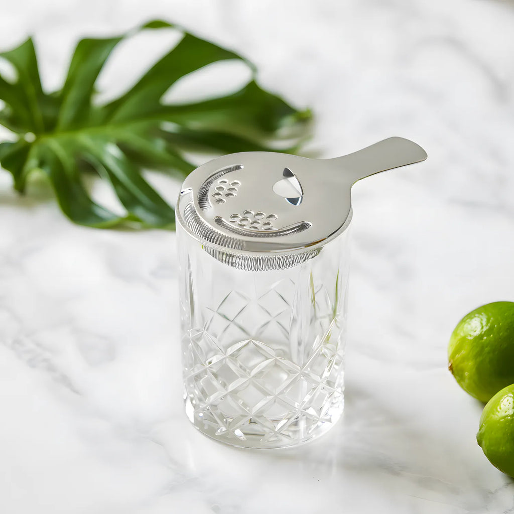 Hawthorne strainer resting on a mixing glass