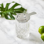 Hawthorne strainer resting on a mixing glass