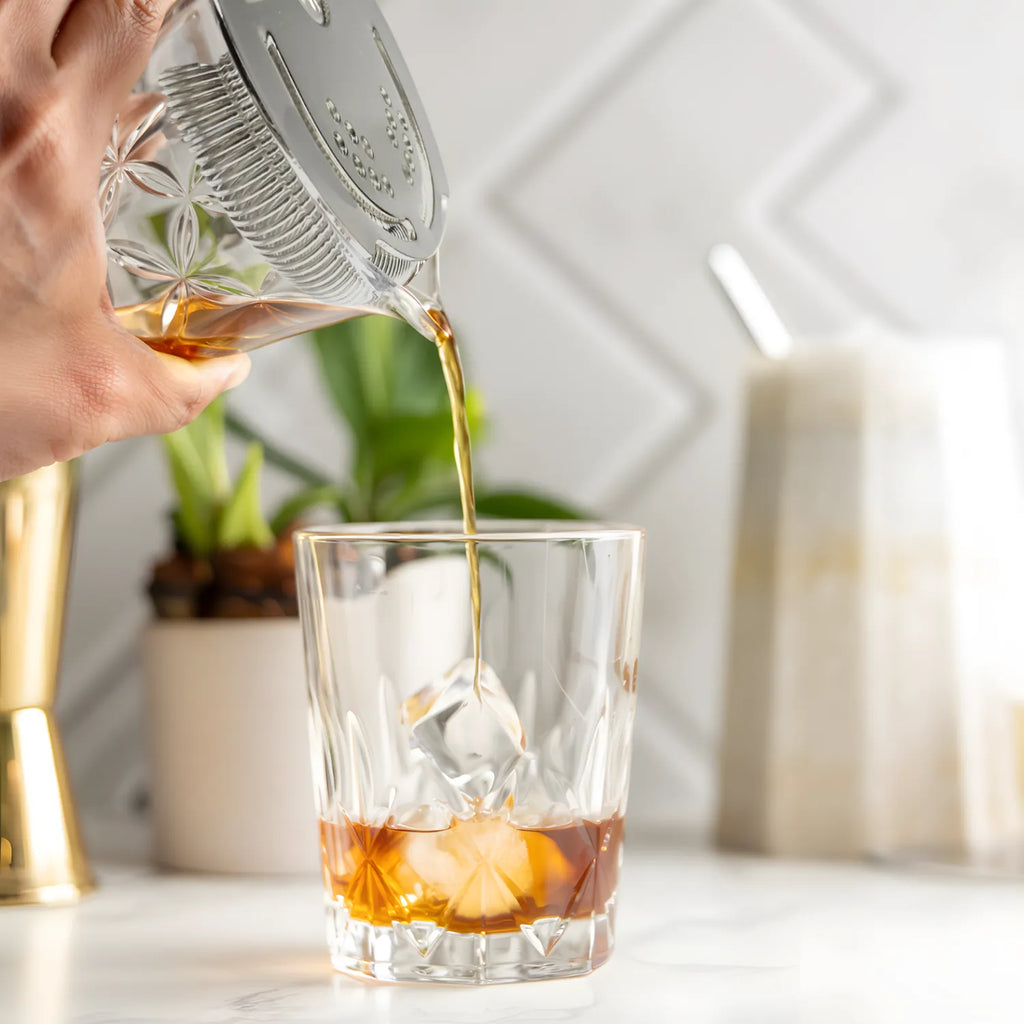 Bartender straining cocktail with a Hawthorne strainer