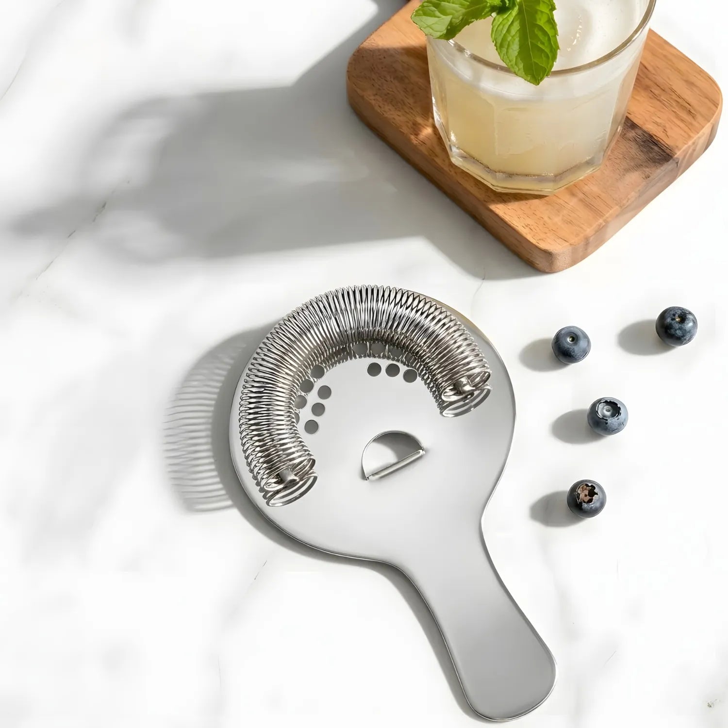 Hawthorne strainer next to a cocktail