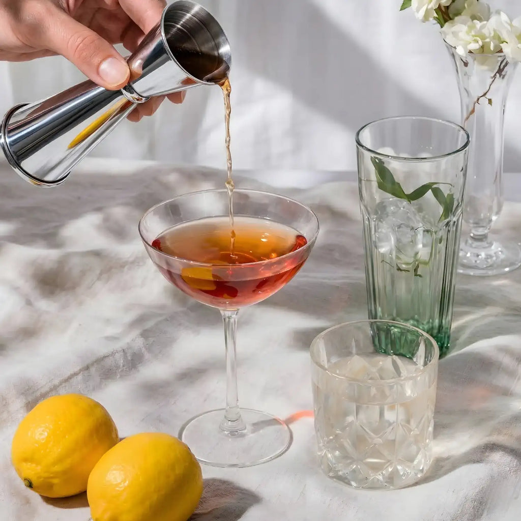 bartender pouring liquor with a Japanese jigger