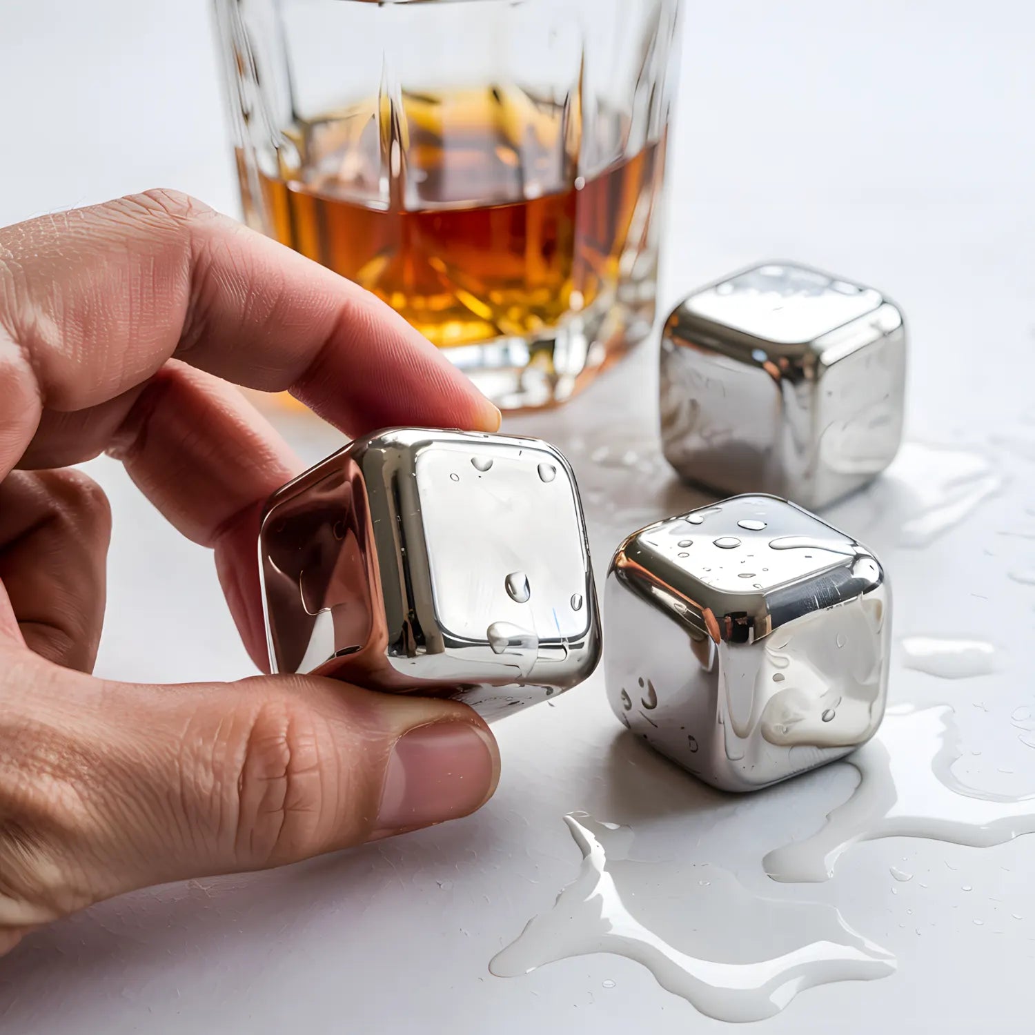 close-up of a stainless steel ice cube in hand